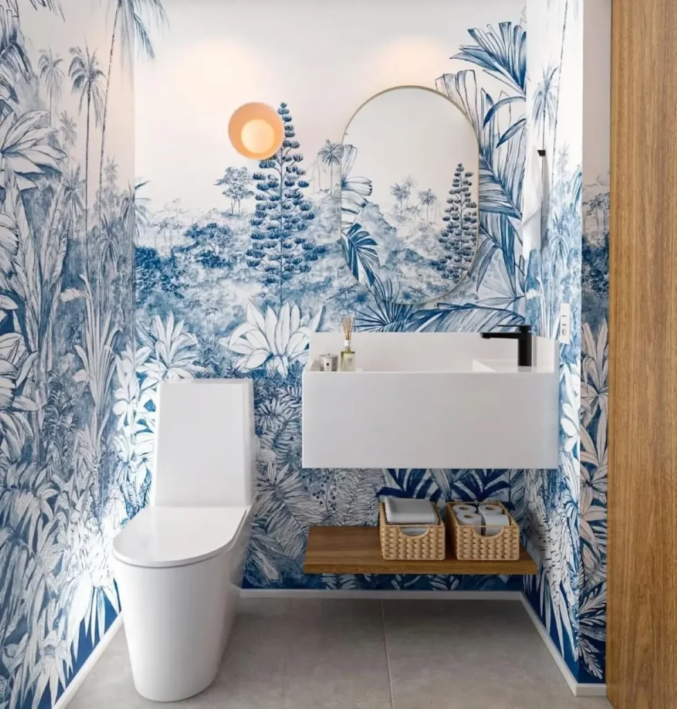 Lavabo com papel de parede maximalista, estilo tropical com estampa azul, prateleira abaixo da pia e espelho na pia.