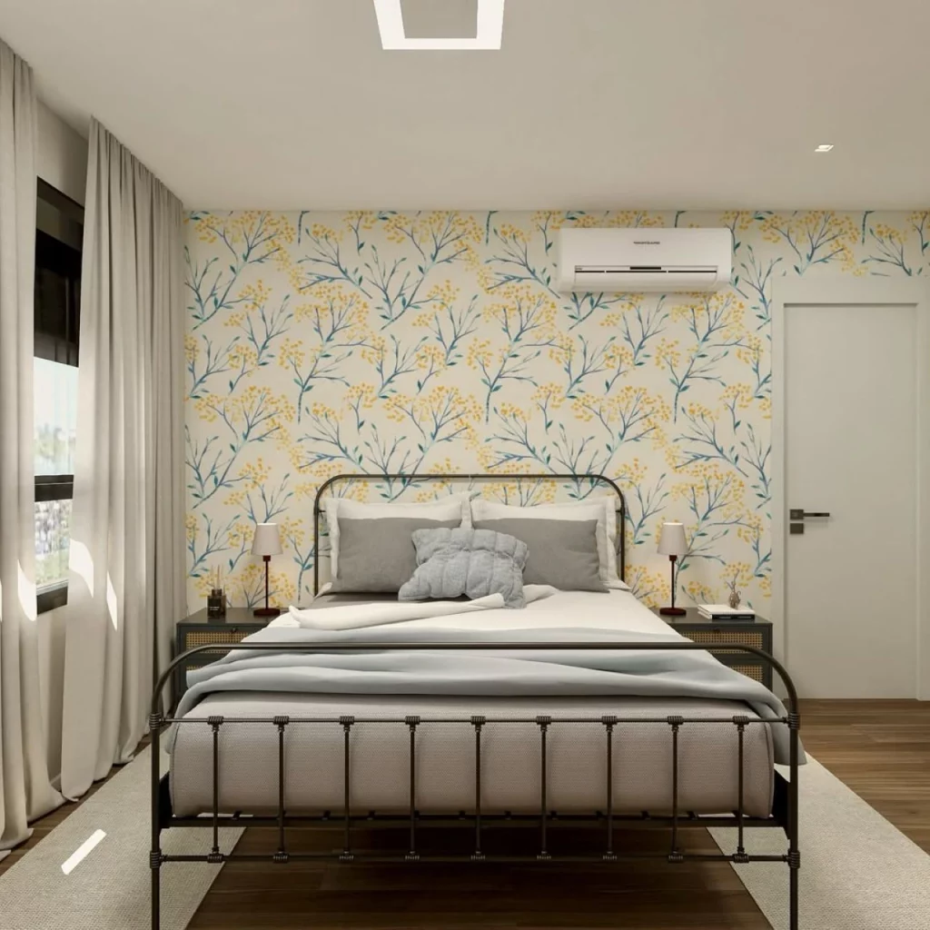 Quarto de casal com cama de grades de ferro e parede com papel de parede floral amarelo.