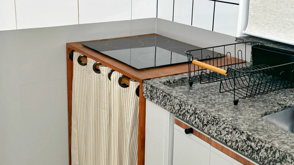 Móvel para cooktop com cortina e tampo de madeira.