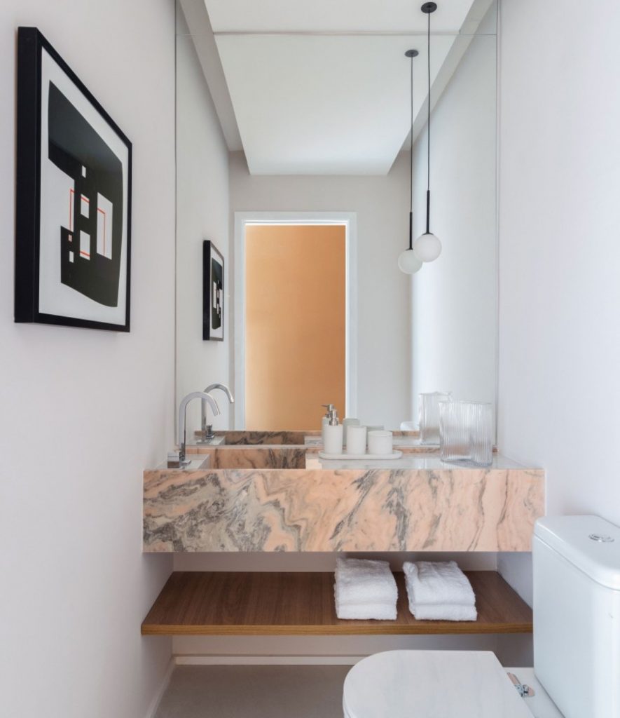 Lavabo elegante com quadro na parede e prateleiras abaixo da pia.