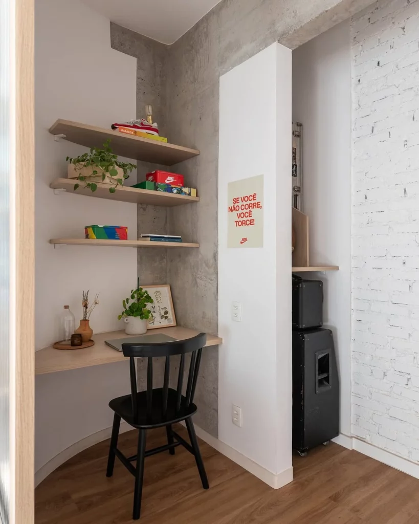 Decoração de canto com prateleiras, mesa, itens diversos e quadro.