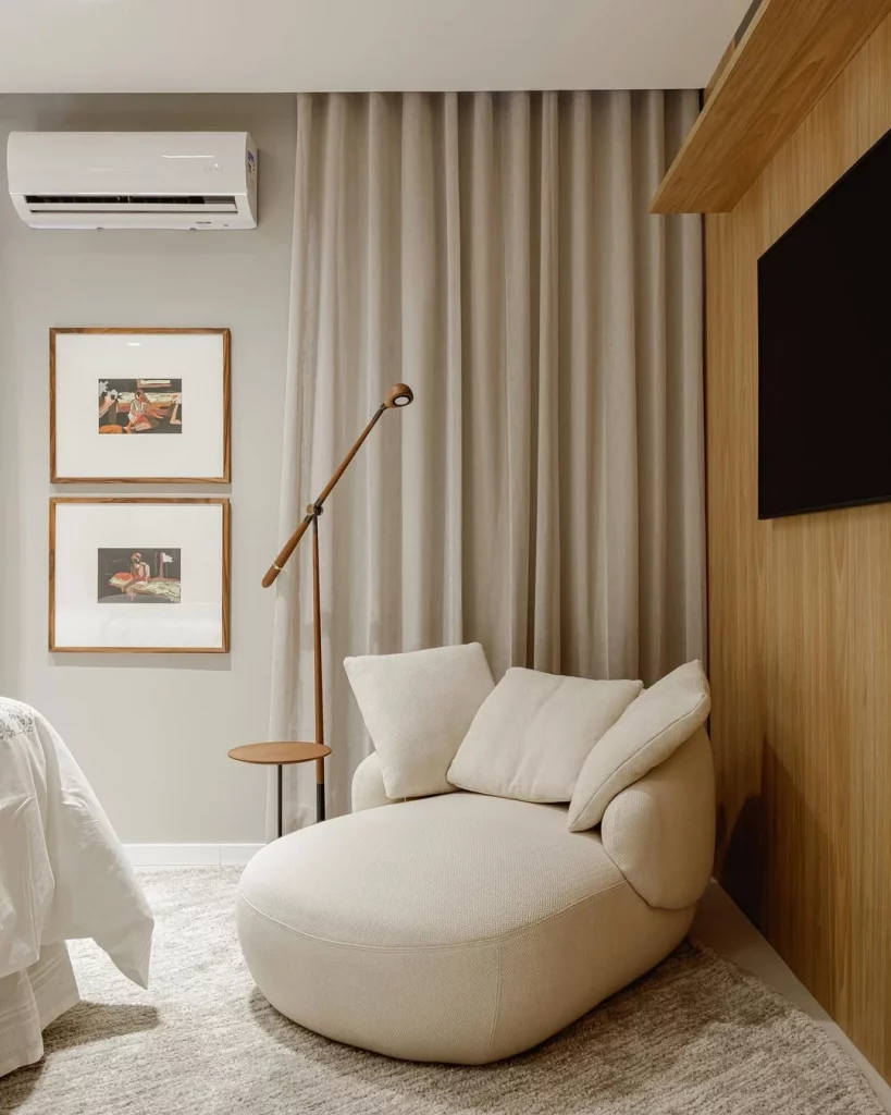 Cortinas, quadros, poltrona branca e luminária moderna.