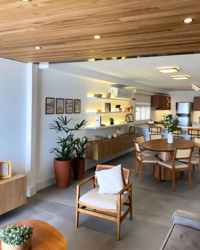 Ambiente em casa com iluminação natural e iluminação artificial amarela, vinda de spots, fitas de LED e painel de LED.