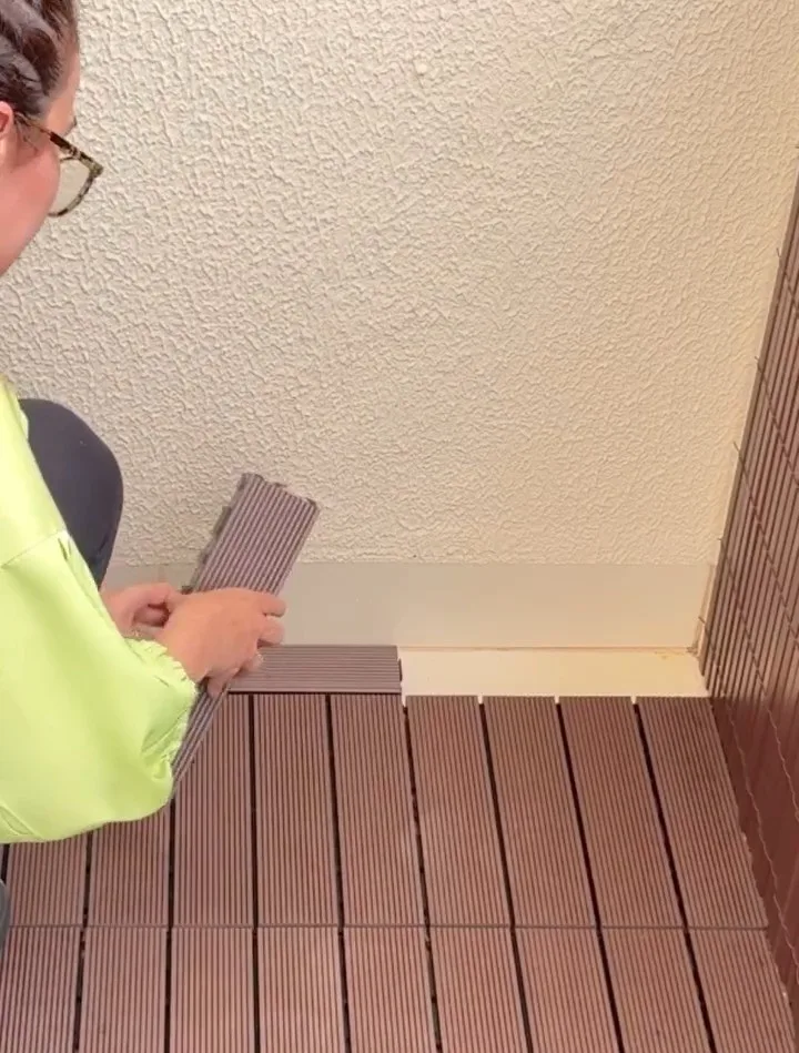Instalando deck de madeira plástica no piso da varanda.