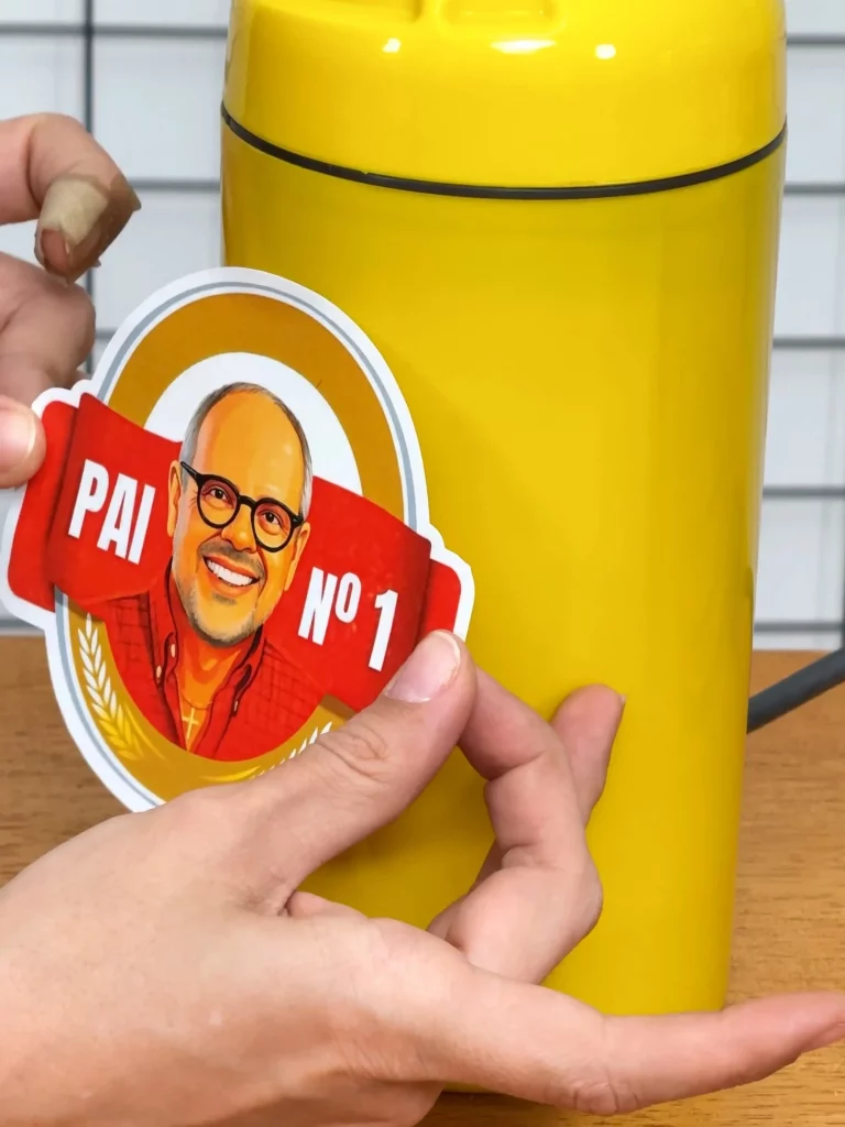 Colocando adesivo personalizado na luminária feita com porta garrafa térmica.
