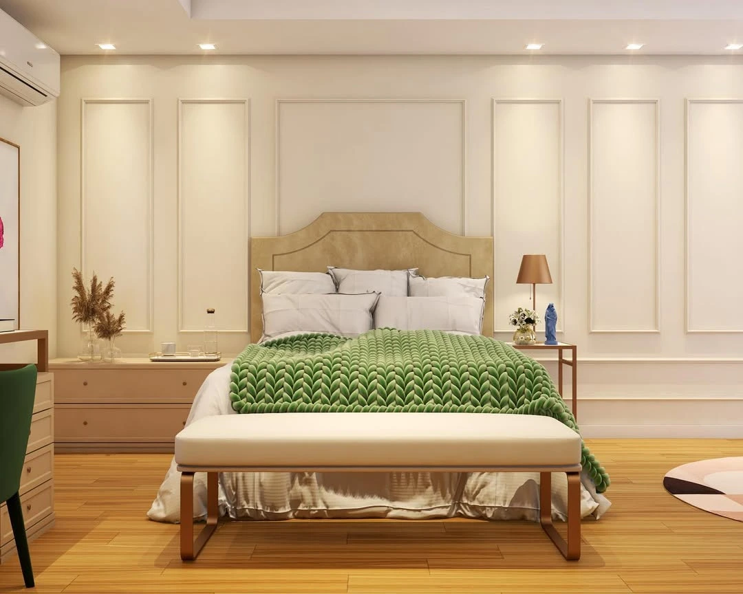 Quarto com cabeceira bege e paarede de boiserie, manta verde vibrante.
