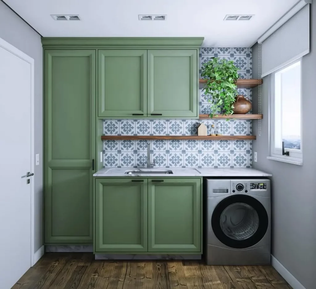 Lavanderia com papel de parede de azulejo português e armários verdes.