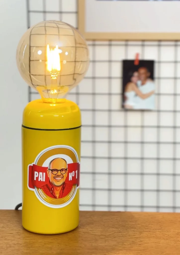 Luminária feita com porta garrafa térmica e lâmpada redonda vintage de luz amarela.
