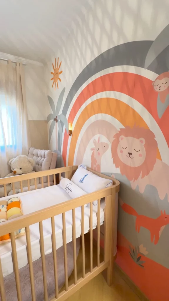 Detalhes da parede de safari com berço e poltrona de amamentação no quarto de bebê.