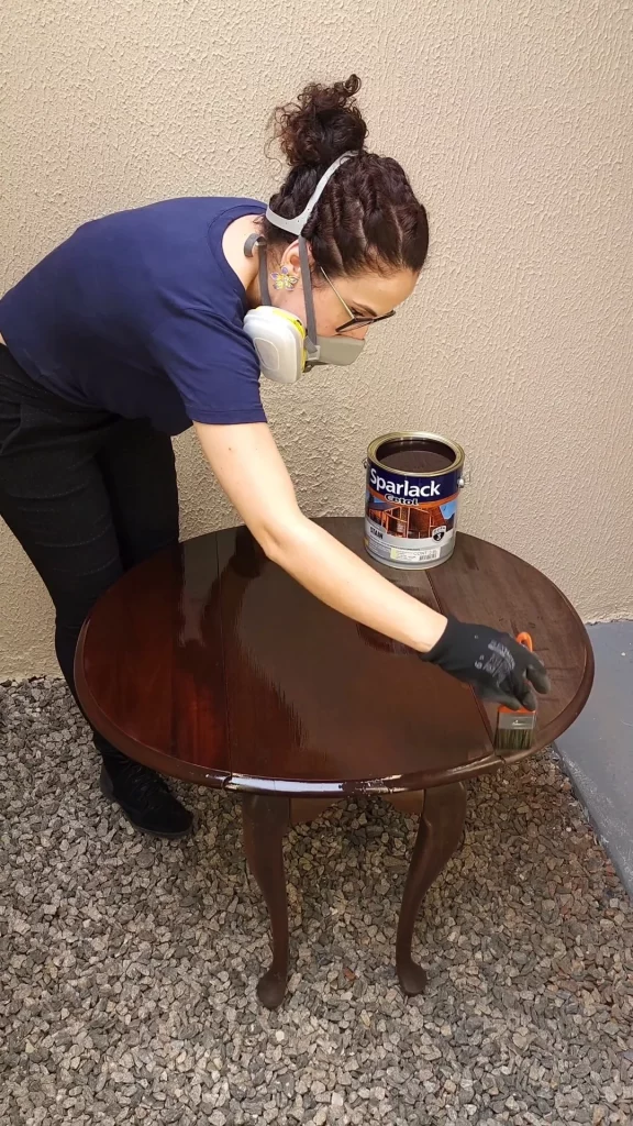 Mesa vintage com stain sendo passado com pincel de tinta.