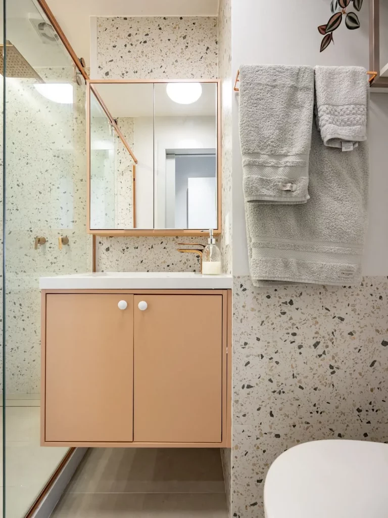 Revestimento liso de pedrinhas e armário bege.