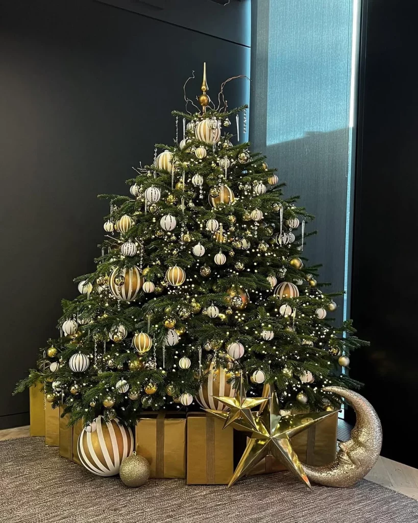 Árvore de natal baixa e cheia de enfeites.