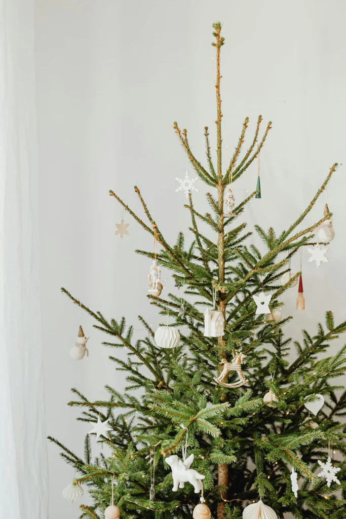 Árvore de natal minimalista com poucos enfeites na cor branca.