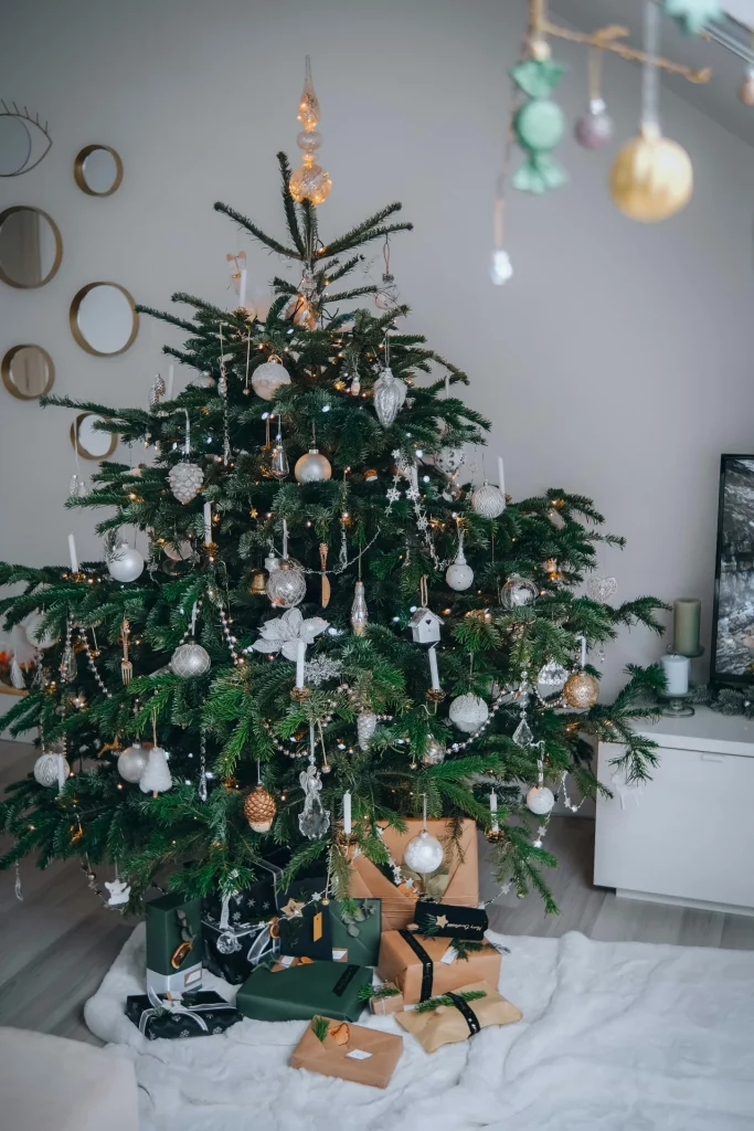 Decoração de árvore de natla minimalista com muitos enfeites brancos.