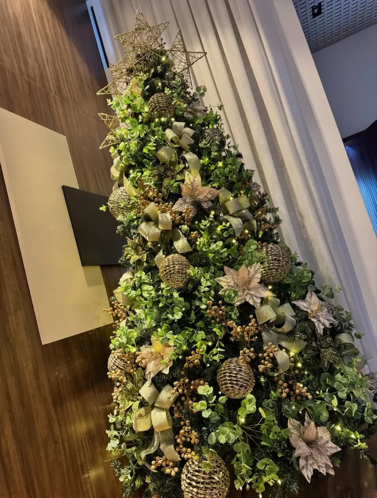 Árvore de natal rústica elegante com laços marrons e flores bege.