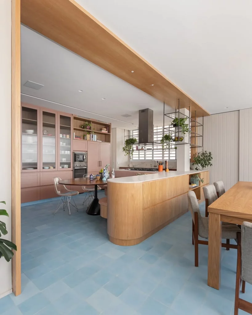 Balcão de canto arredondado para cozinhaa e que combina com a mesa de jantar da sala.