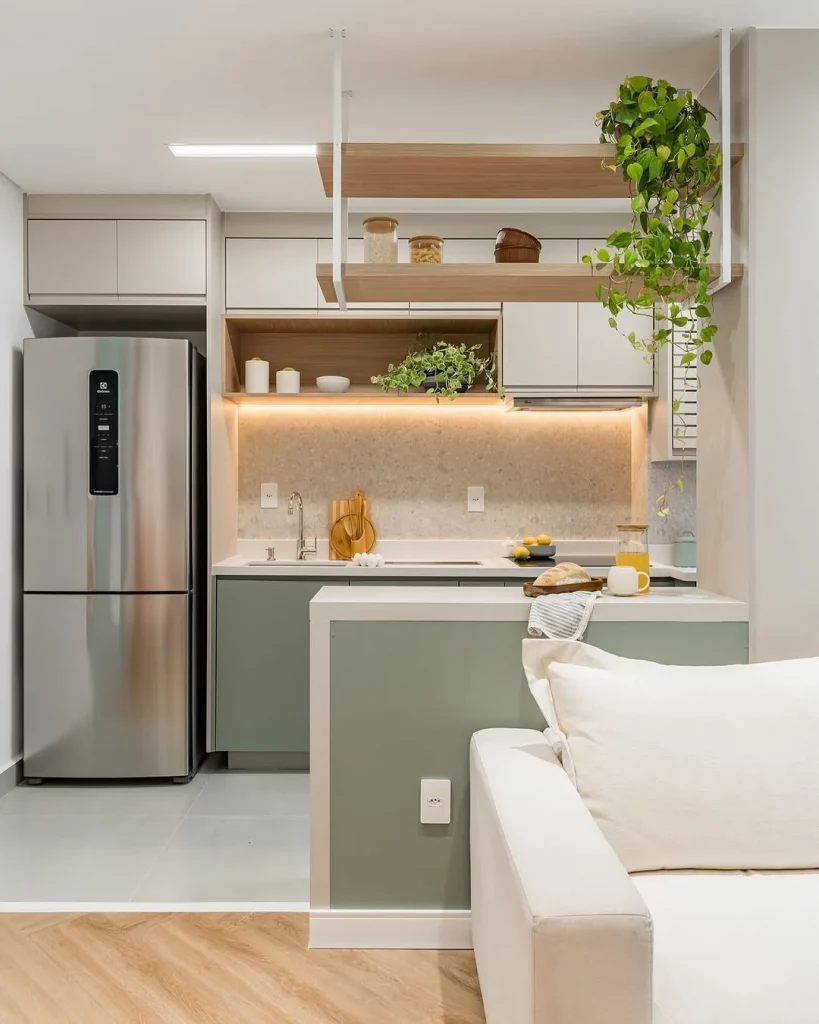 Cozinha conjugada com sala e iluminação discreta nos armários.