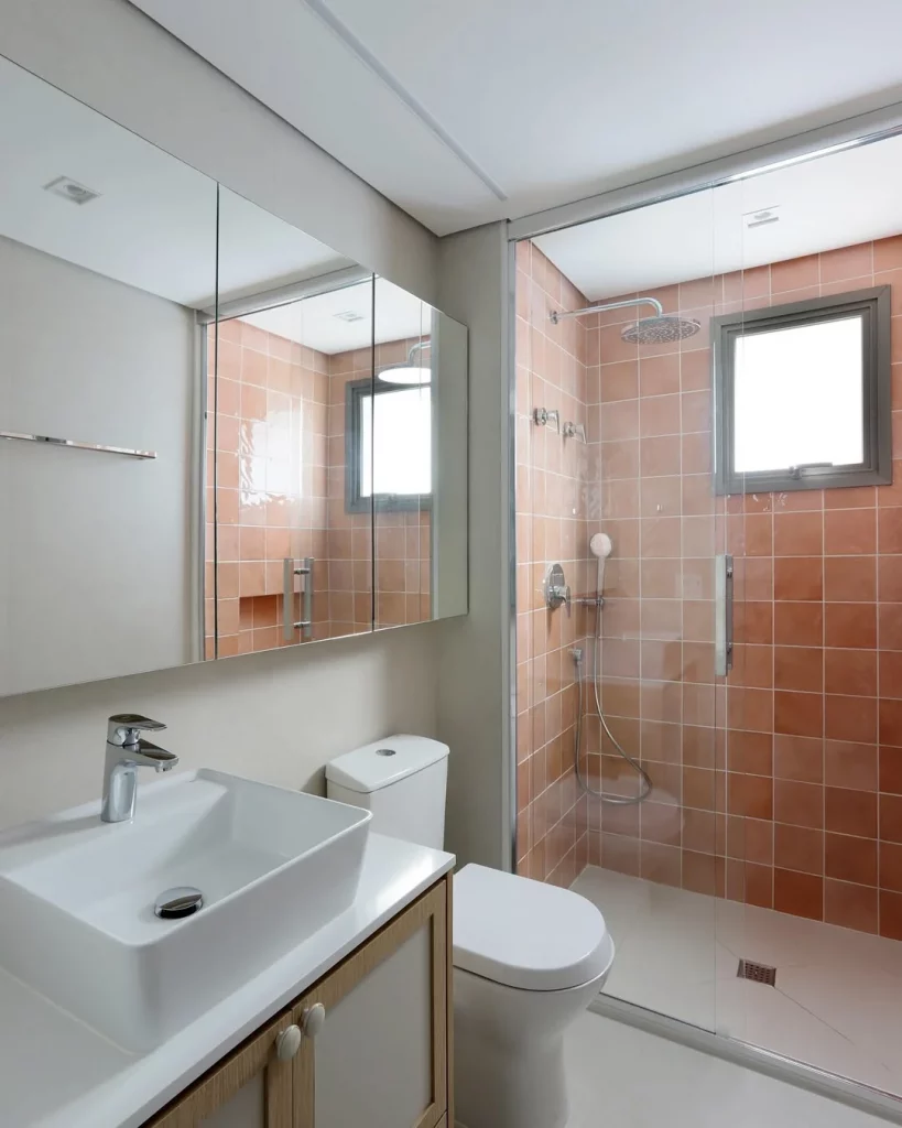 Banheiro com azulejo laranja e piso de porcelanato acetinado neutro.
