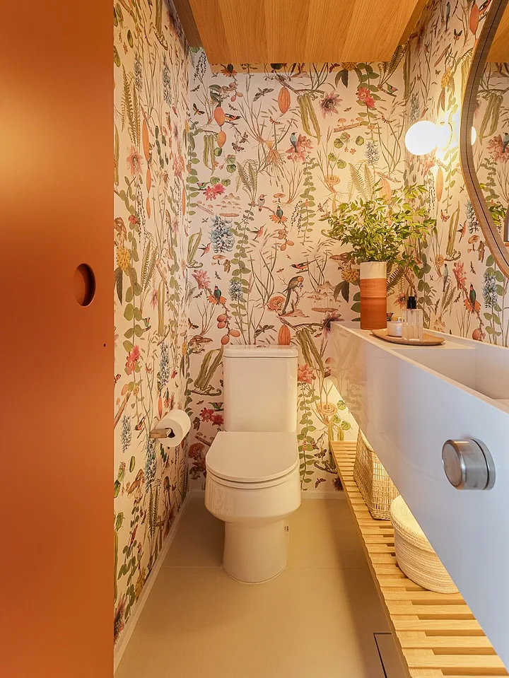 Banheiro com estampa maximalista e iluminação.