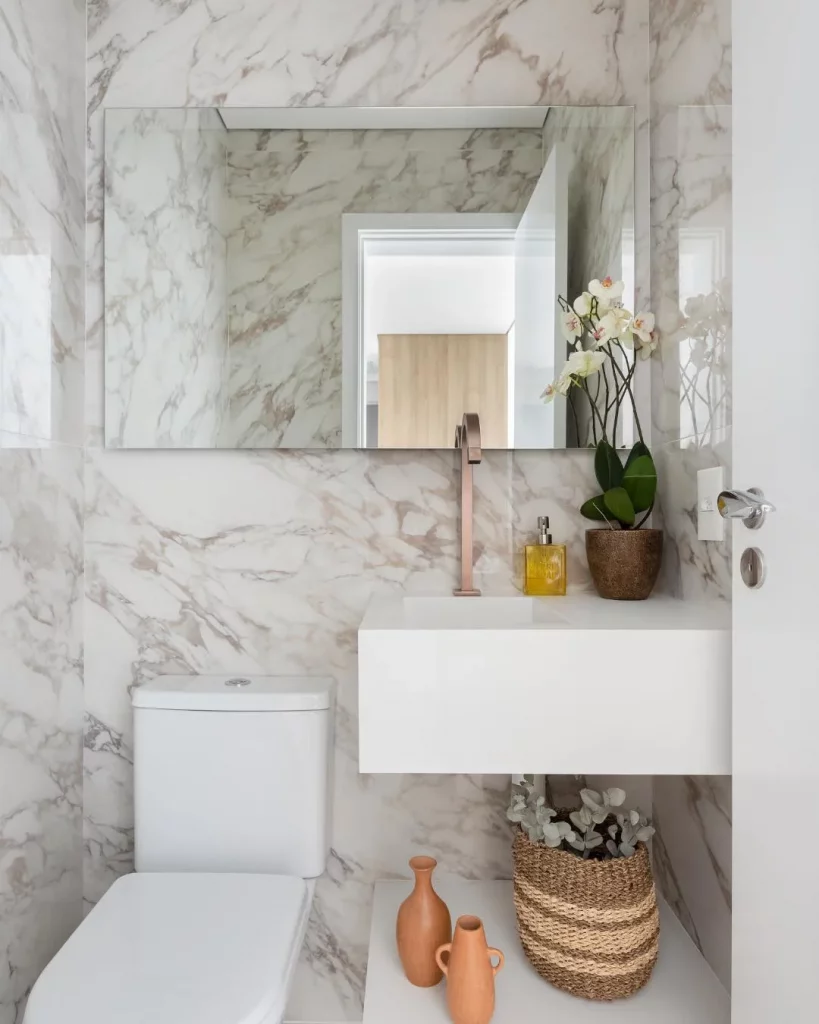 Banheiro com mármore nas paredes.