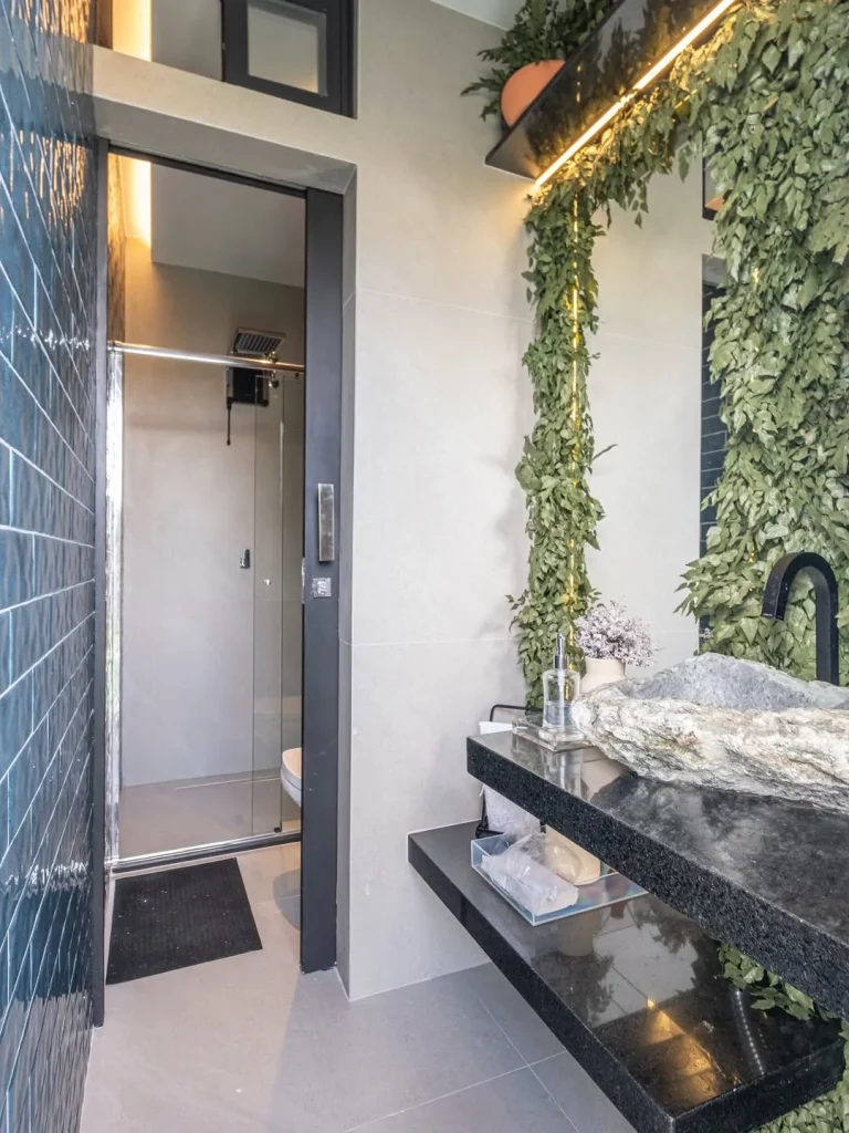 Banheiro com plantas no espelho.