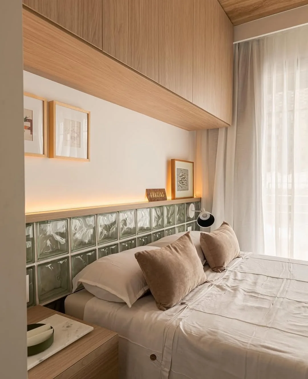 Cabeceira de cama diferente, feita com azulejos de vidro e iluminação embutida.