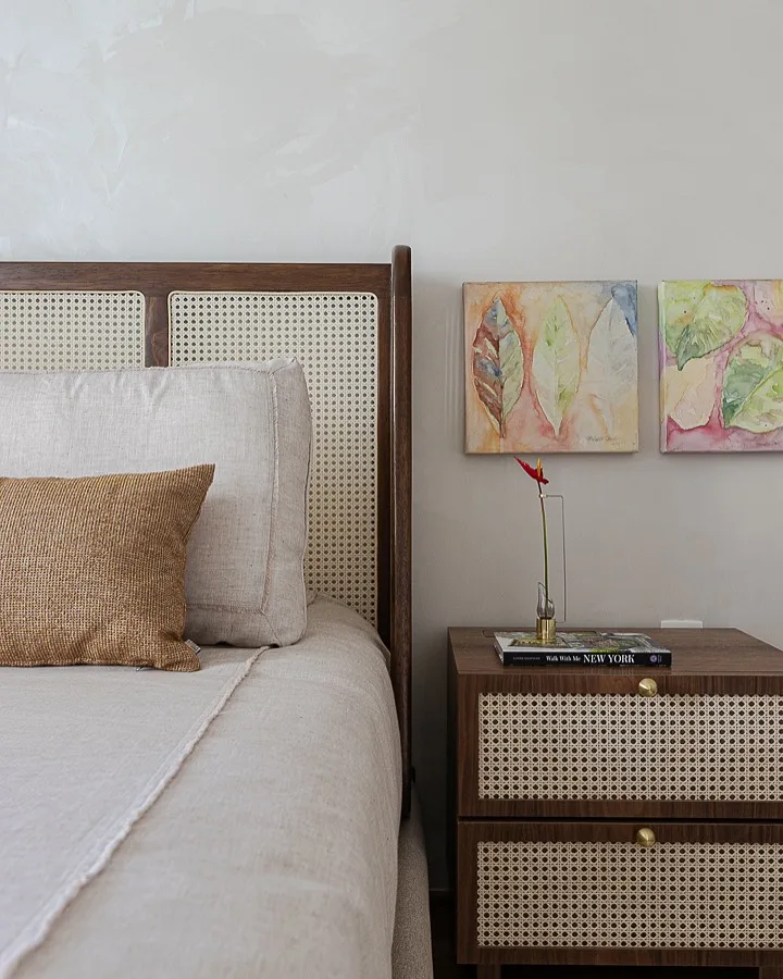 Cabeceira de cama palha indiana com madeira em quarto neutro.