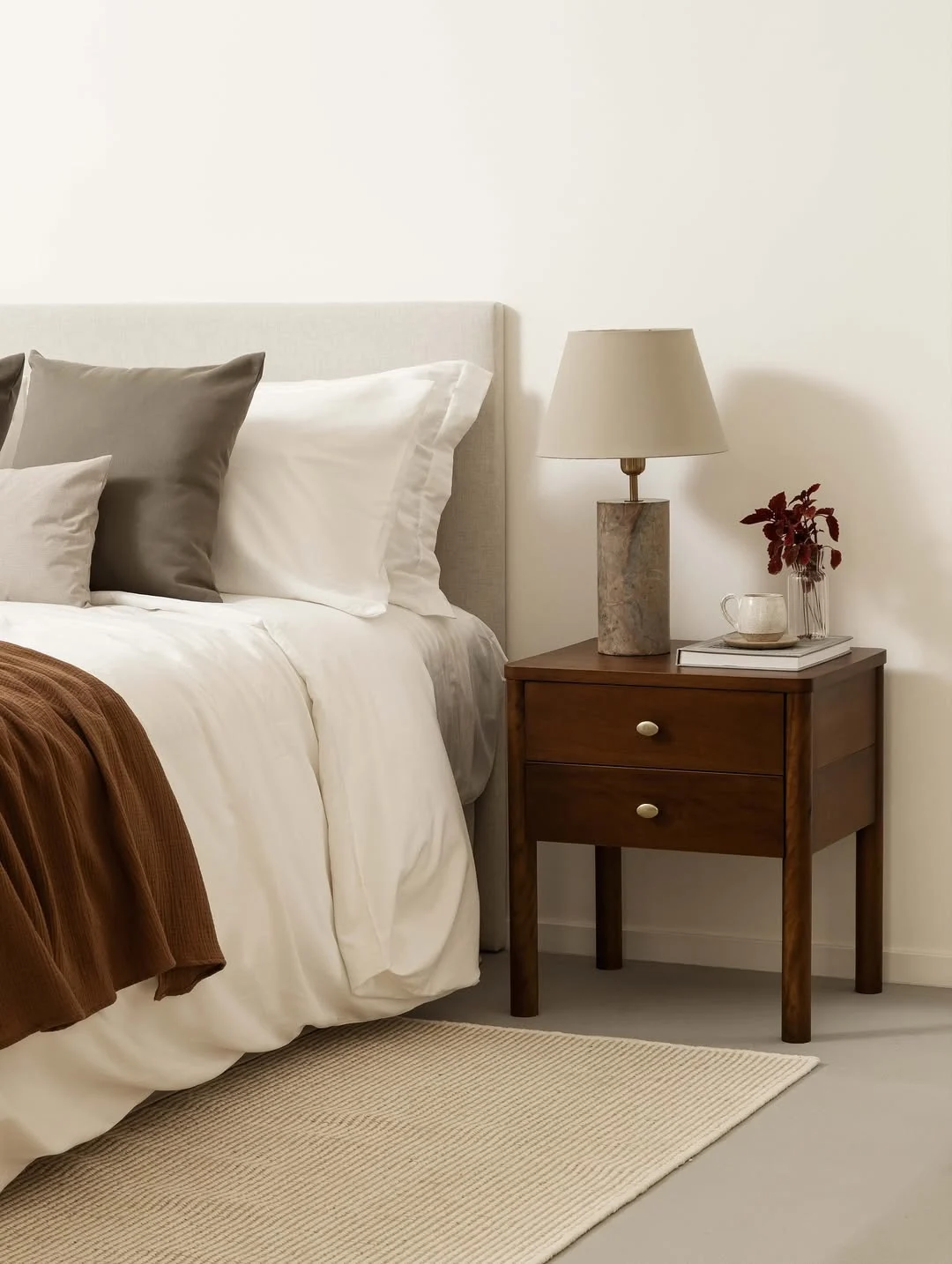 Quarto com cabeceira em tom cinza claro e estética minimalista com marrom dando contraste.