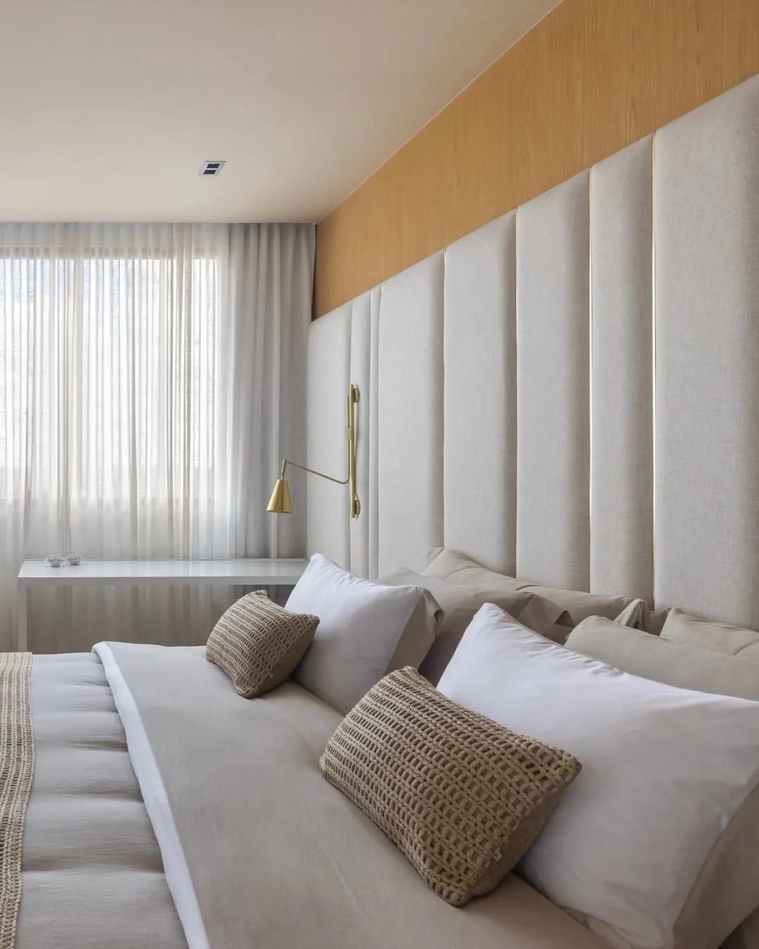 Cabeceira de cama modular em tom cinza no quarto neutro.