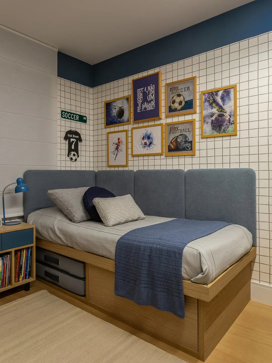 Cabeceira modular no quarto infantil masculino contornando a cama e em tom de azul.
