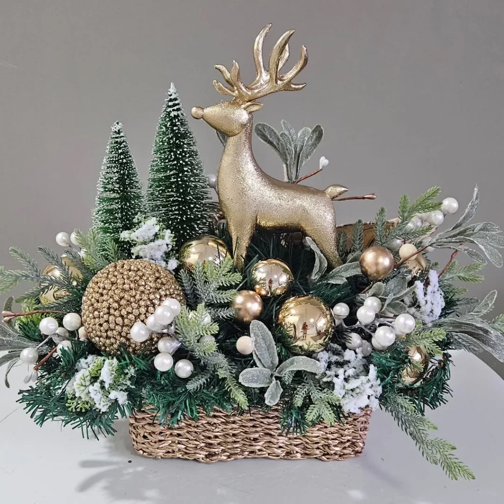 Ceentro de mesa com rena e bolas douradas de natal.