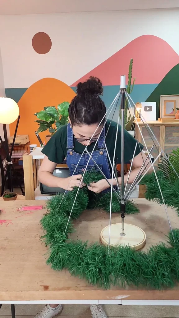 Colocando festão da árvore de natal feita com guarda-chuva velho estragado.