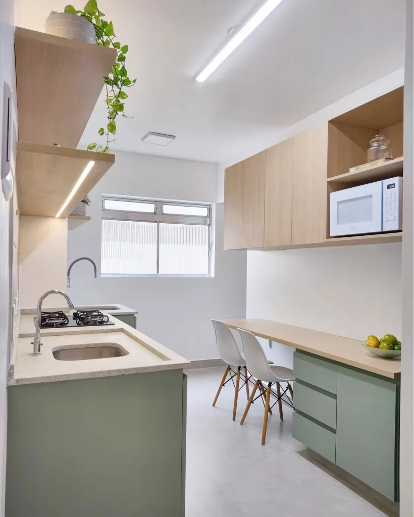 Cozinha aconchegante com armários verde claro e madeira.