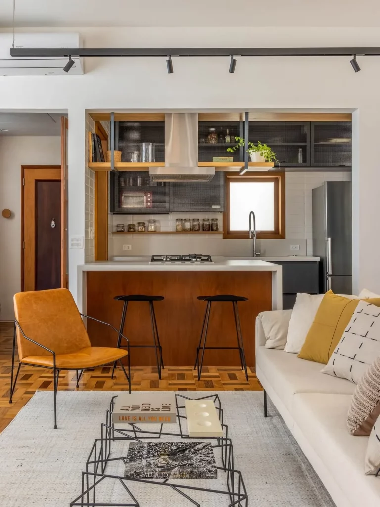 Cozinha e sala compartilhada com elementos amarelos e madeira.