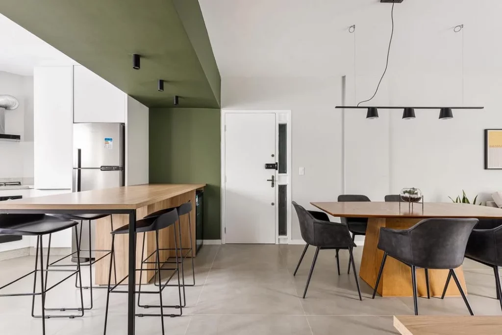 Cozinha conjugada com sala de jantar e pintura setorizada para dividir os ambientes.