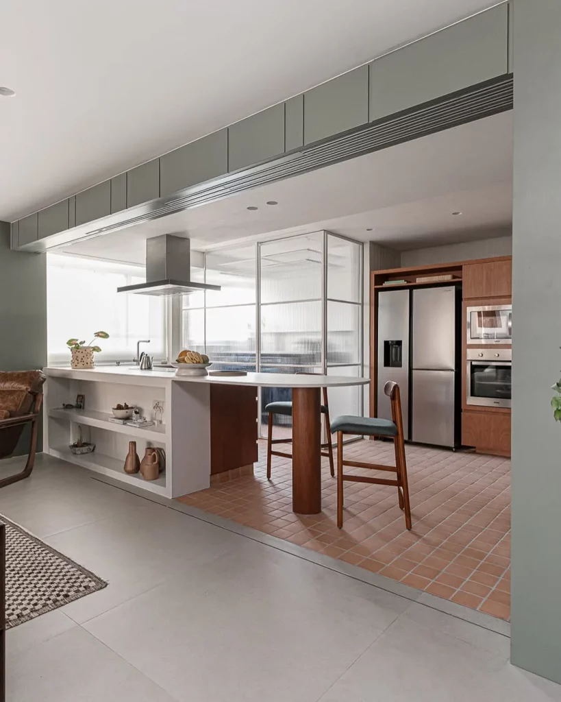 Sala e cozinha conjugada com porta de vidro no fundo e ambiente espaçoso.