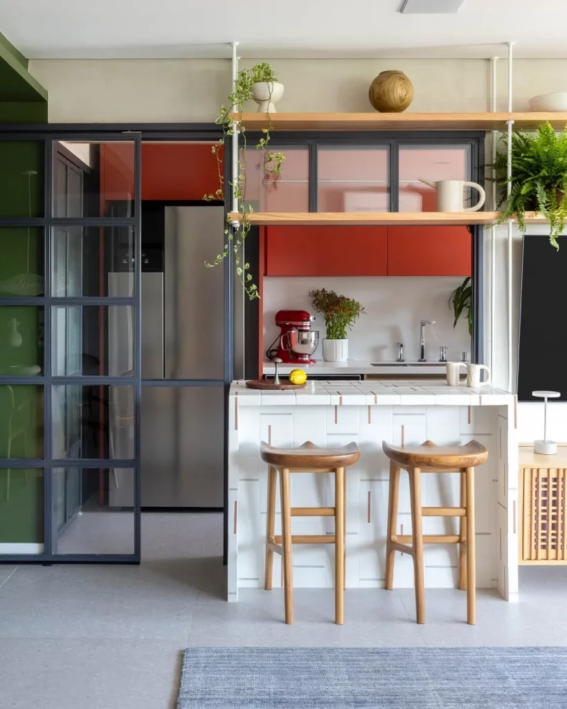 Cozinha conjugada com sala de estar e pintura vermelha para dar destaque.