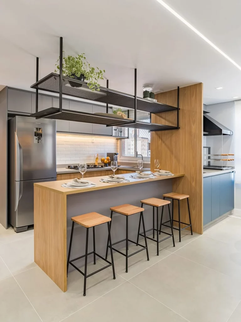 Cozinha com bancadas modernas e elementos de madeira e ferro, piso acetinado.