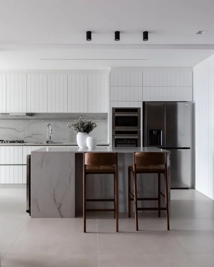 Cozinha e sala conjugada minimalista e com destaque para materiais de couro.