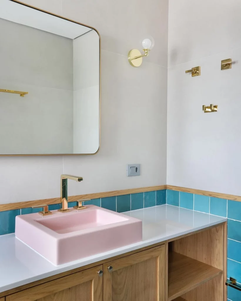 Cuba rosa no banheiro com paredes brancas e vestimento azul.