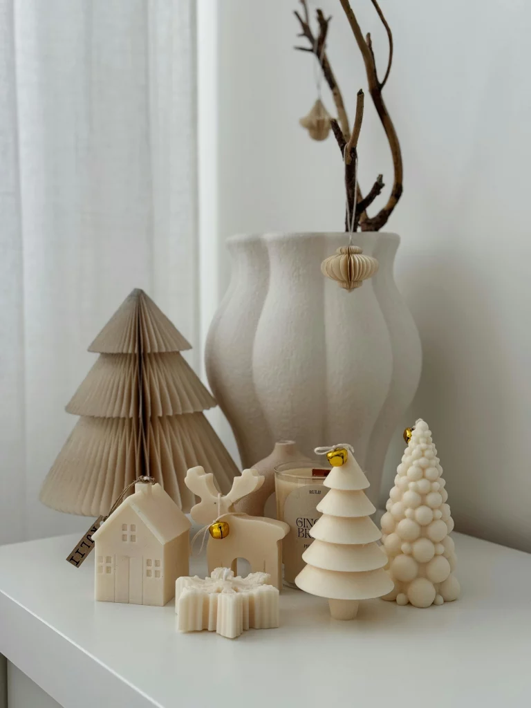 Velas temáticas de natal neutras no canto do aparador.