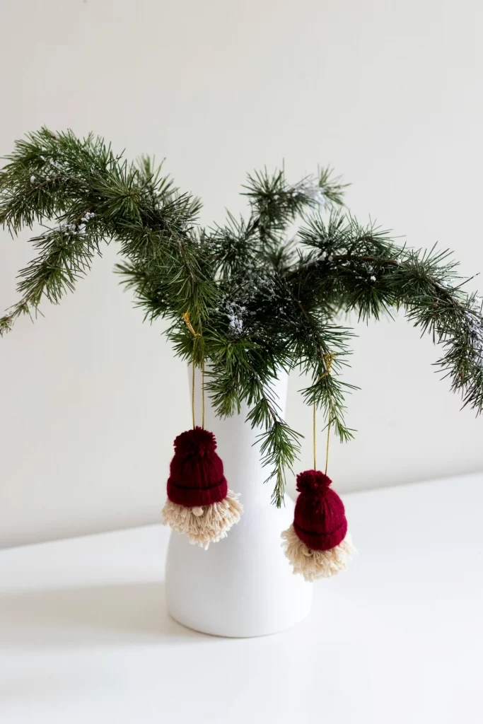 Enfeite de natal minimalista com ramos e vaso branco.