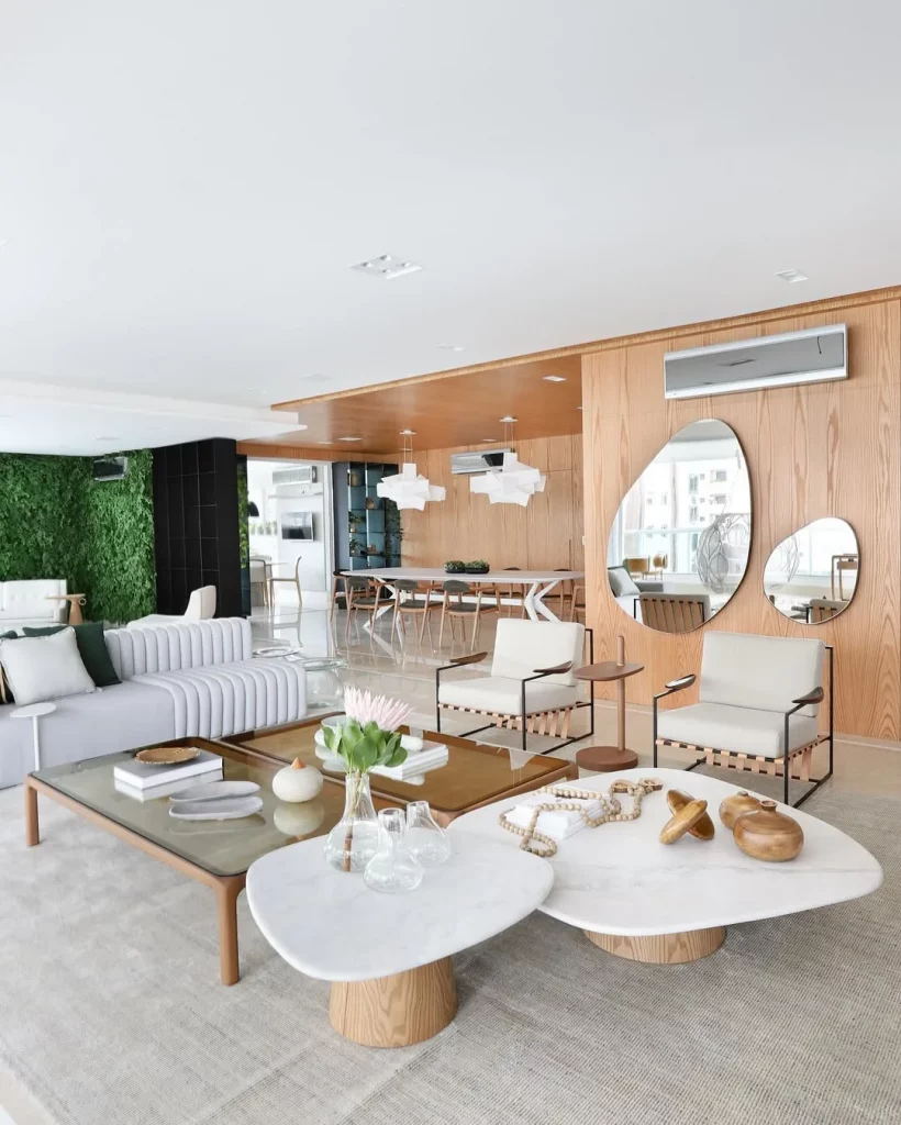 Sala de estar elegante com dois espelhos orgânicos na parede de madeira.