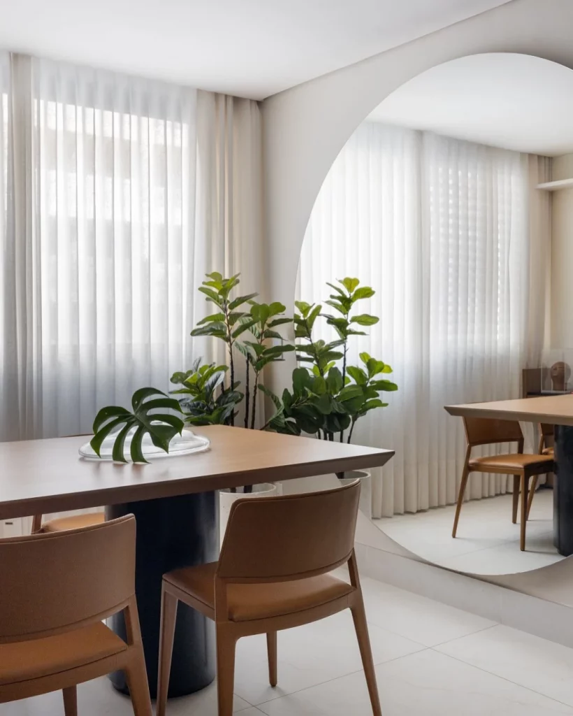 Espelho redondo grande tomando conta da parede da sala de jantar.