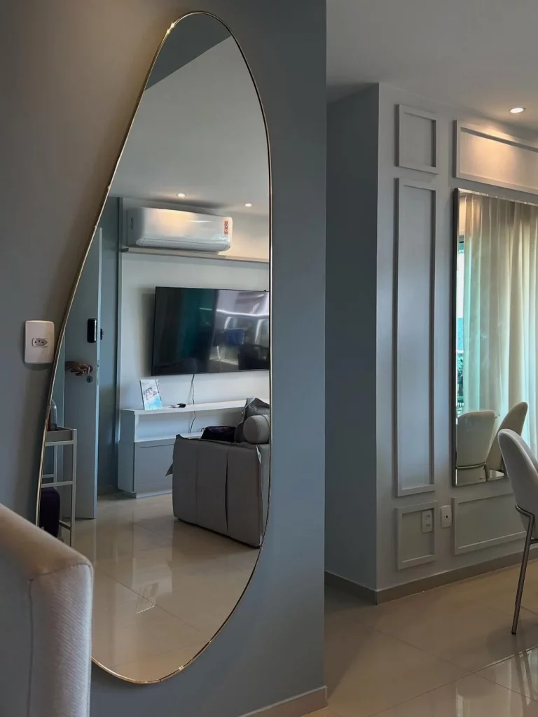 Espelho orgânico no canto da parede da sala.