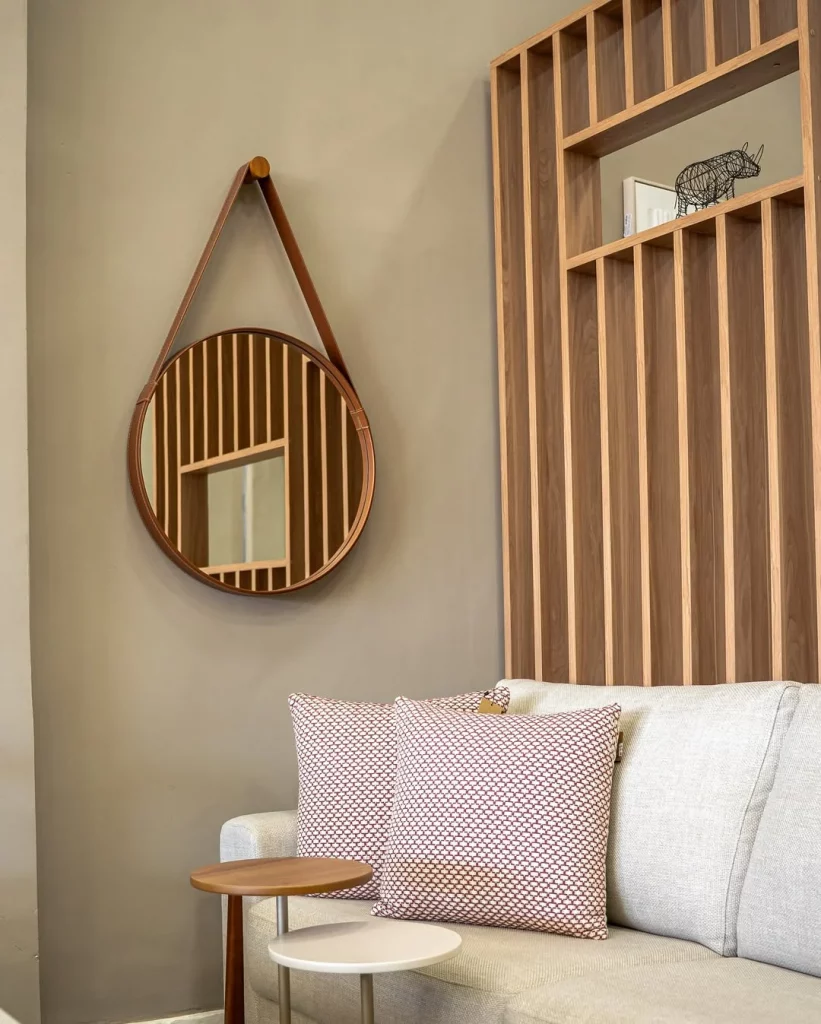 Espelho redondo com faixa de couro para pendurar no canto da sala.