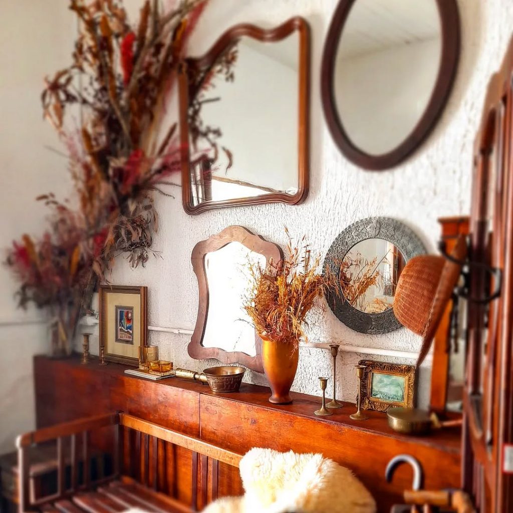 Galeria de espelhos vintage na sala estilo boho.