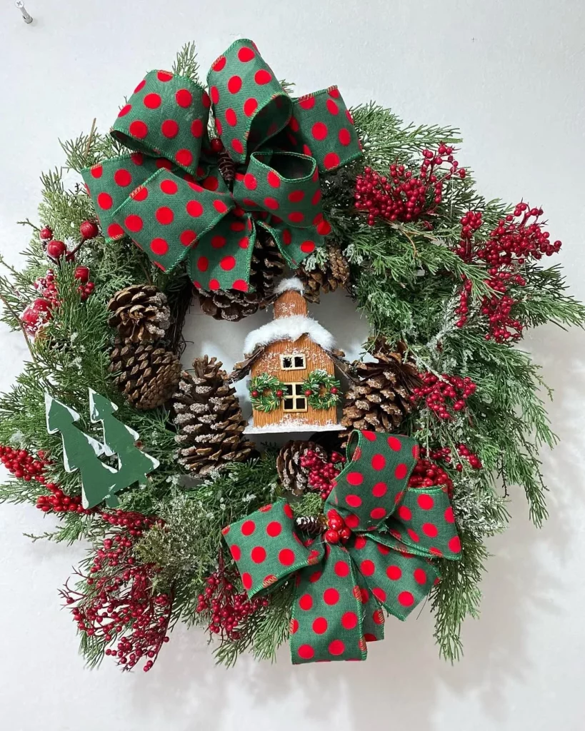 Guirlanda de natal vermelha com verde, com pinhas e casinha.