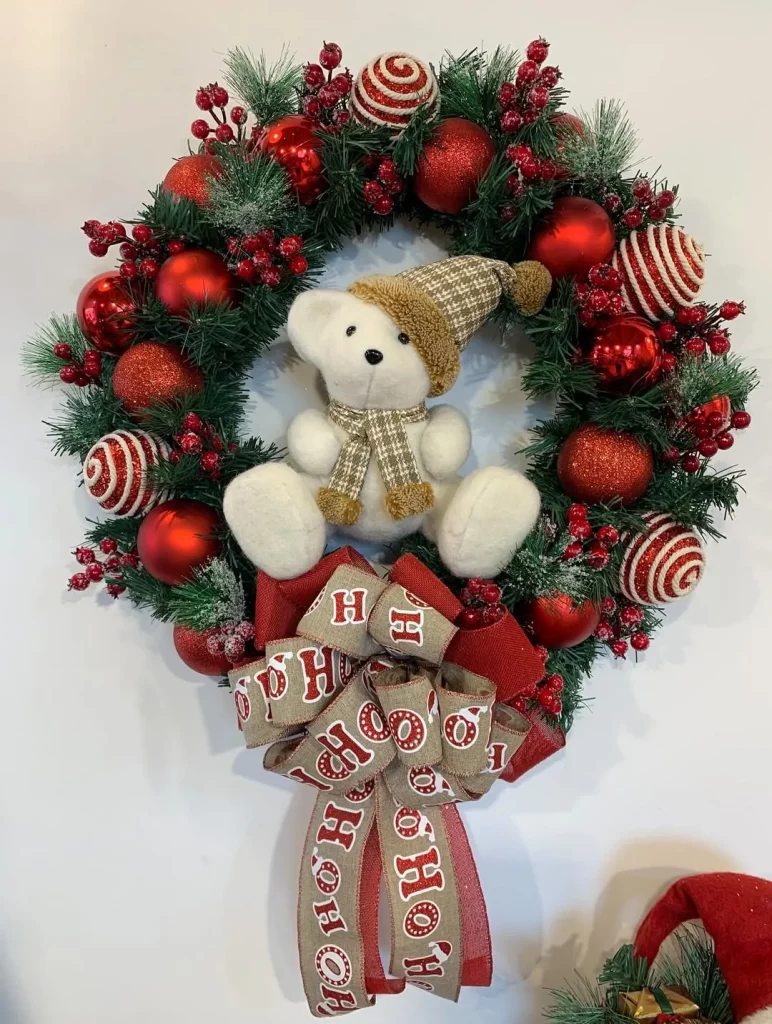 Guirlanda de natal com ursinho e bolas vermelhas.