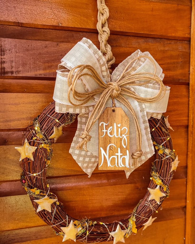 Guirlanda de natal rústica com laço e placa.
